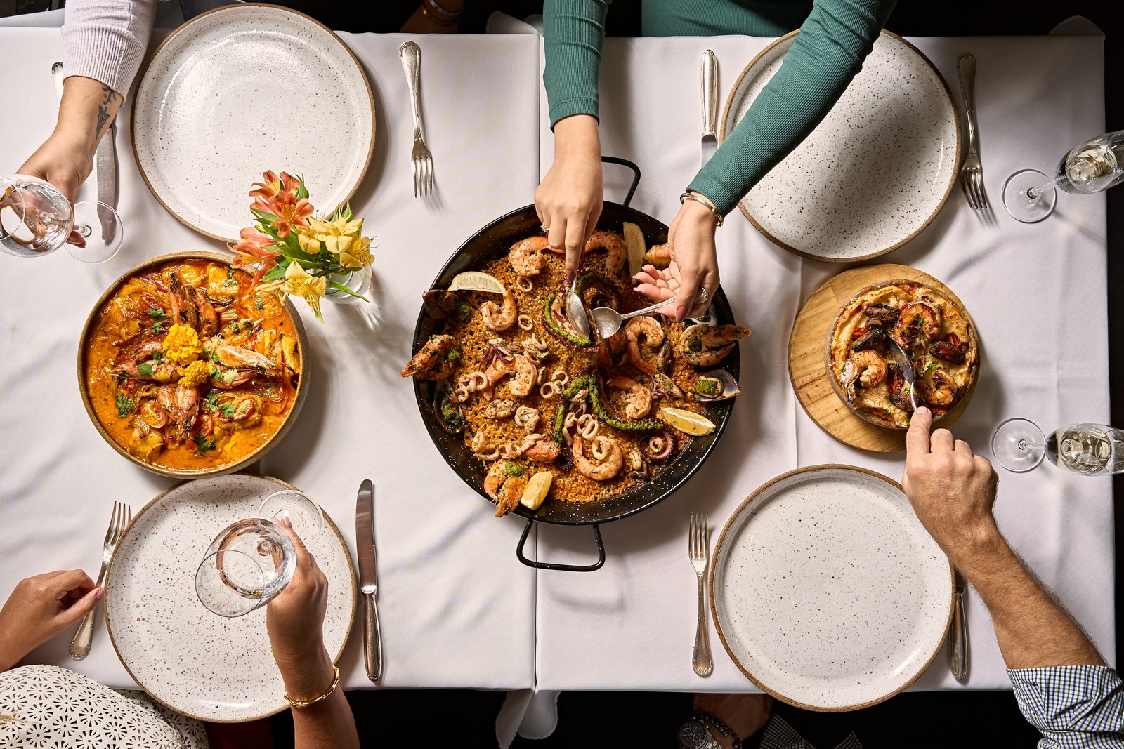 Amigos servindo paella à mesa
